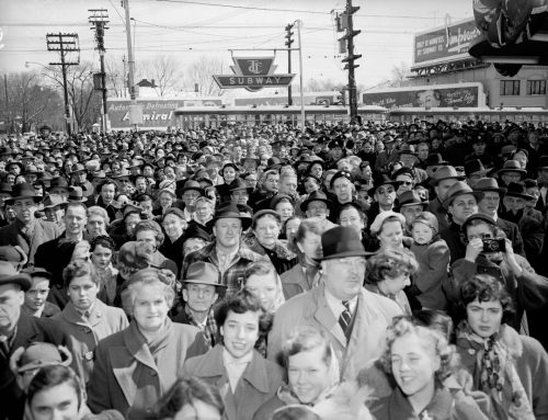 People in a large crowd smile at the camera. Behind them is a TTC subway sign.