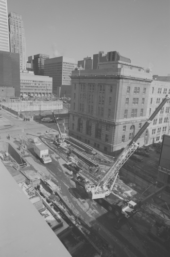 Heavy machinery in roadway. Background show office buildings.