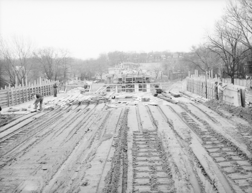 Preparation of ground for subway trackbed installation and hoarding running along work area.