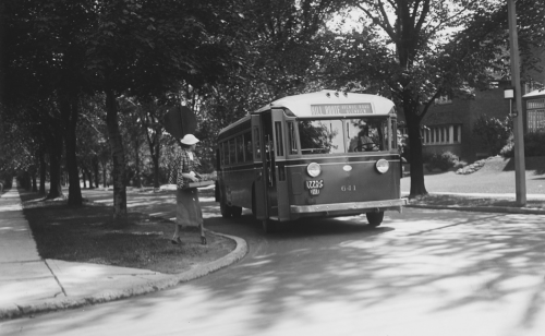 Woman boarding bus on tree lined road