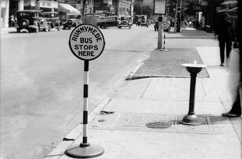 A round sign on top of a shoulder-high pole. It says "Runnymede bus stops here."