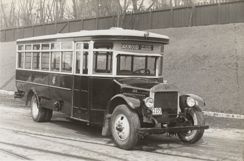 A small bus with a front end that looks like a truck, and a shiny boy with white trim around the windows.