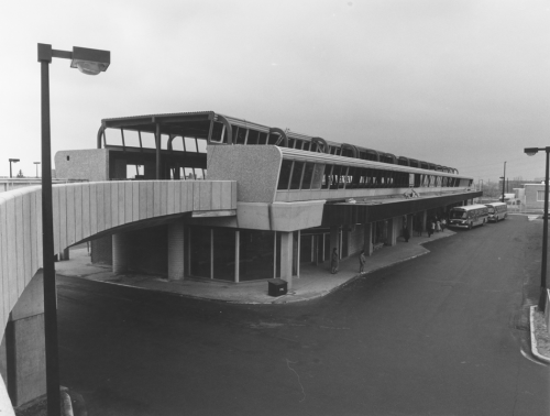 Station and bus waiting area with elevated track structure in place. Buses located at bus waiting area.