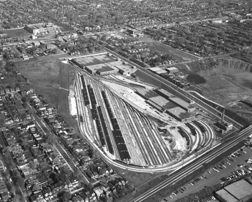 Subway yard and buildings in middle and surrounding residential area.