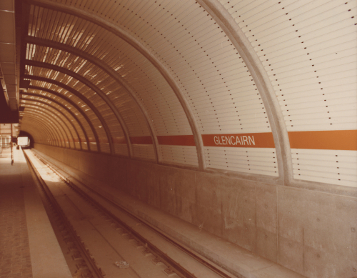 White tiled wall with orange banner of Glencairn Station.