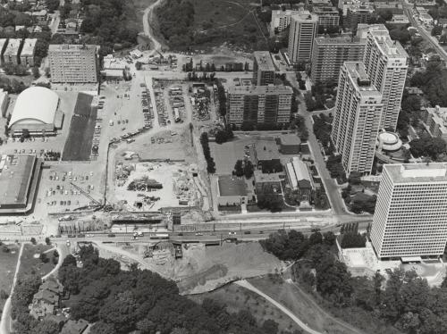 Construction site surrounded by apartment buildings and a church.