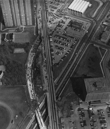 Aerial view of railway tracks, subway tunnel construction, and Bloor Street, includes subway station and parking lot.