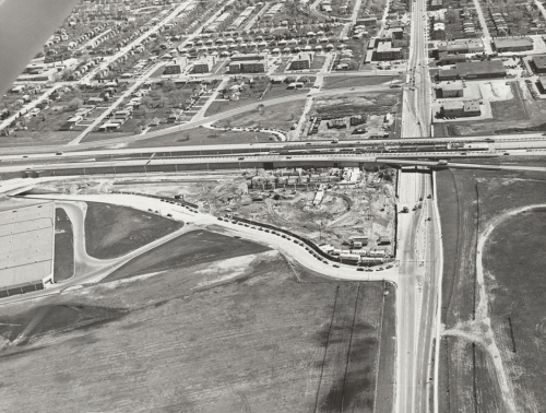 Excavation beside roadway with buildings in distance