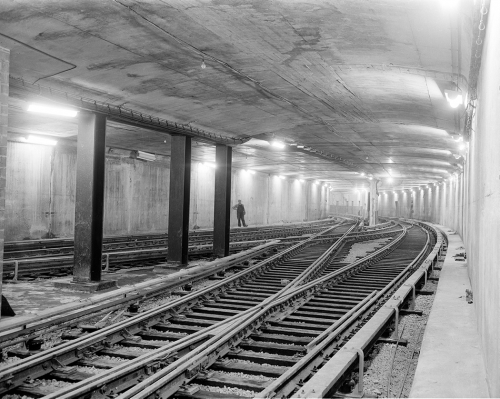 A square concrete tunnel with overlapping sets of tracks. 