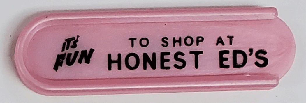 Pink plastic token holder with black print ad for Honest Ed's