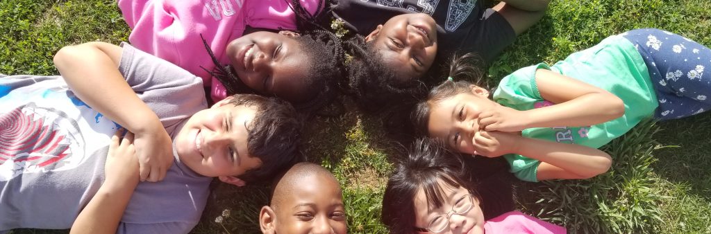 6 kids laying down in a circle