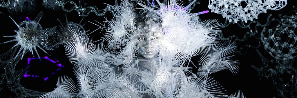 Futuristic artist rendering of a person set against a black space-like background, with white gauzy patterns and molecular structures floating about.