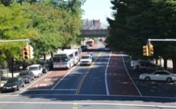 A bus driving towards an intersection on an offset bus lane