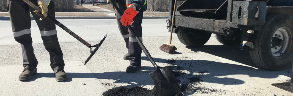 Image of two works filling in a pothole
