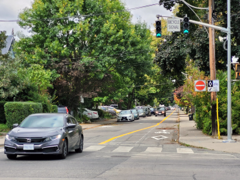 Car driving south on Woodfield Road at Dundas Street East, with a contra-flow bicycle lane in the opposite direction.