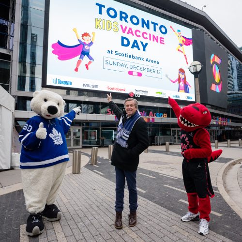 Mayor John Tory standing next to mascots 