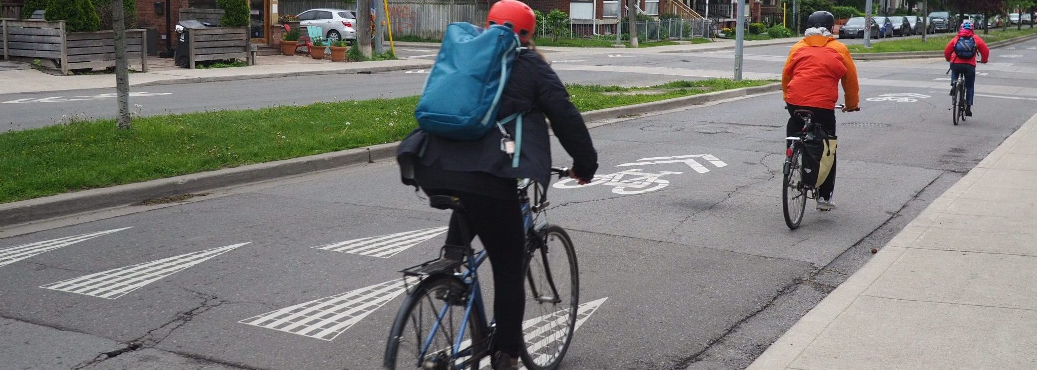 Speed hump on Shaw St southbound at Lobb Ave with three people on bikes riding down the street