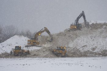 heavy machinery make space for more snow at the snow storage site
