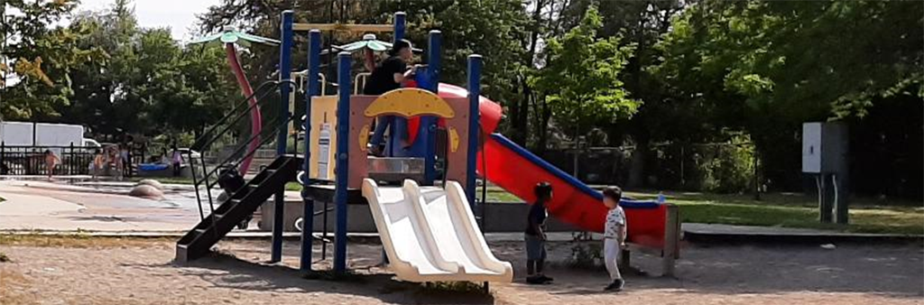 A photograph of Lanyard Park Playground which features a small play structure with multiple slides and climbing opportunities.