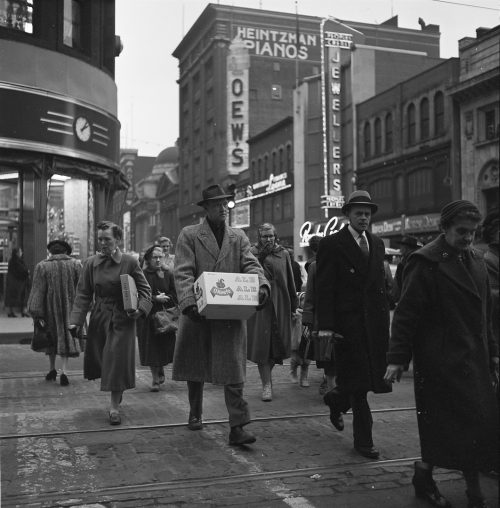 Photograph of a man carrying a case of beer