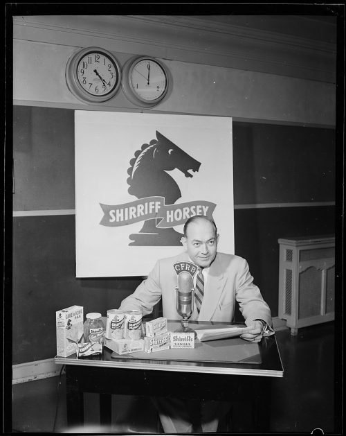 Photograph of newscaster behind microphone