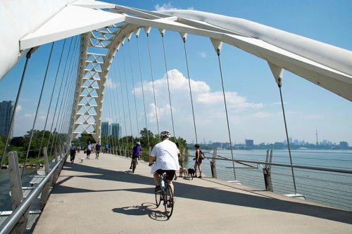 The Humber Bay Arch Bridge is a pedestrian and bicycle bridge that connects two sides of the Humber River located south of Lake Shore Boulevard West in Toronto. Built in 1994, this iconic structure design of double-ribbed steel pipe arches is influenced by the First Nations Thunderbird and spans 456-feet-long.