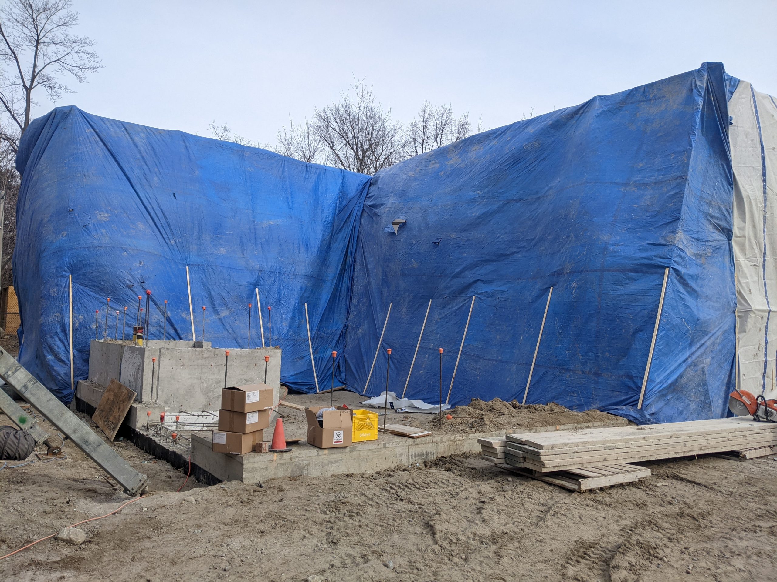 Exterior view of the Zamboni garage covered by tarps to provide protection from the elements while work continues through the winter months. 