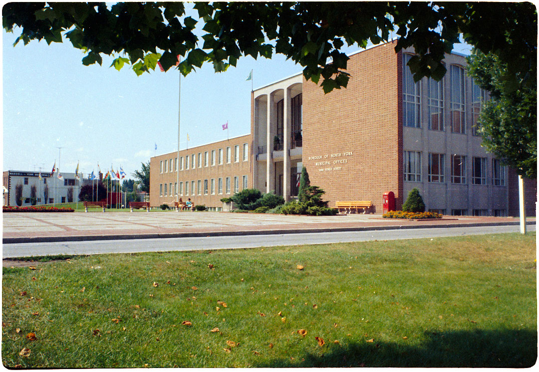 Photograph of large brick building with grass in foreground.