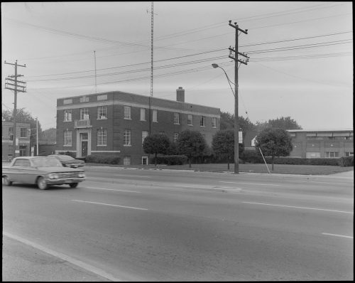 View of two story brick building with road in foreground.