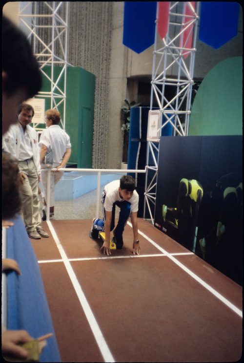 Colour view of boy crouching down in sprint starting position. 
