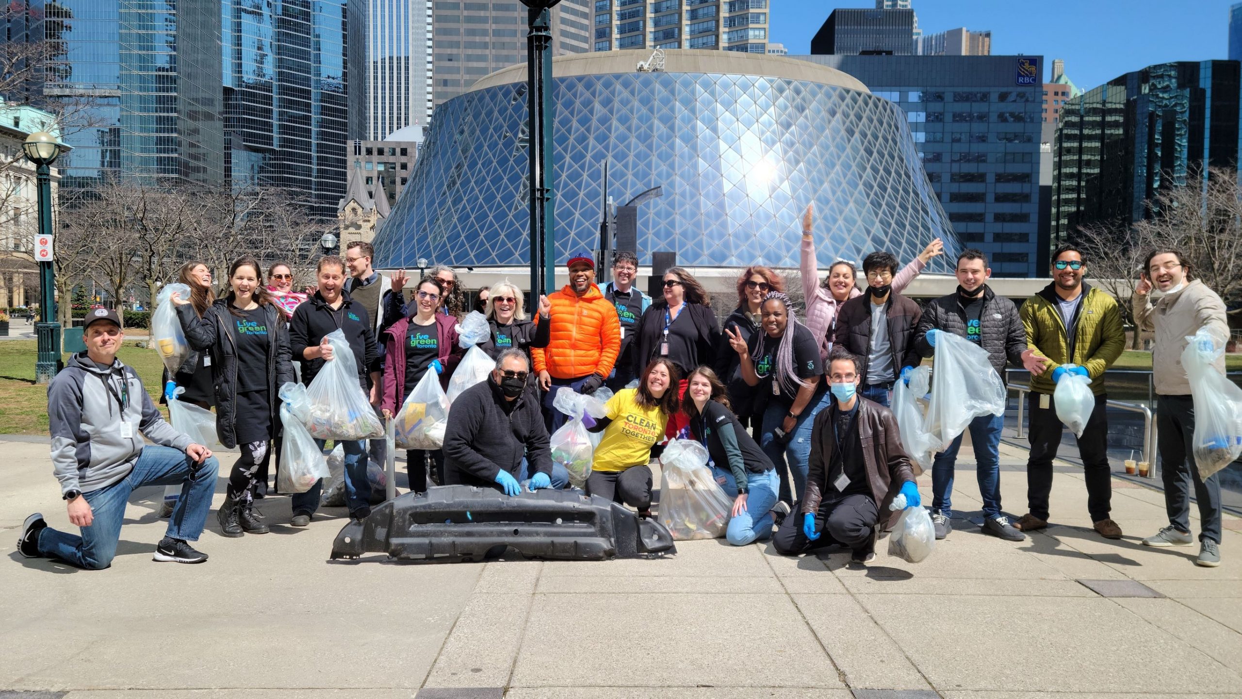 A team of people holding garbage collected at a clean up initiative.