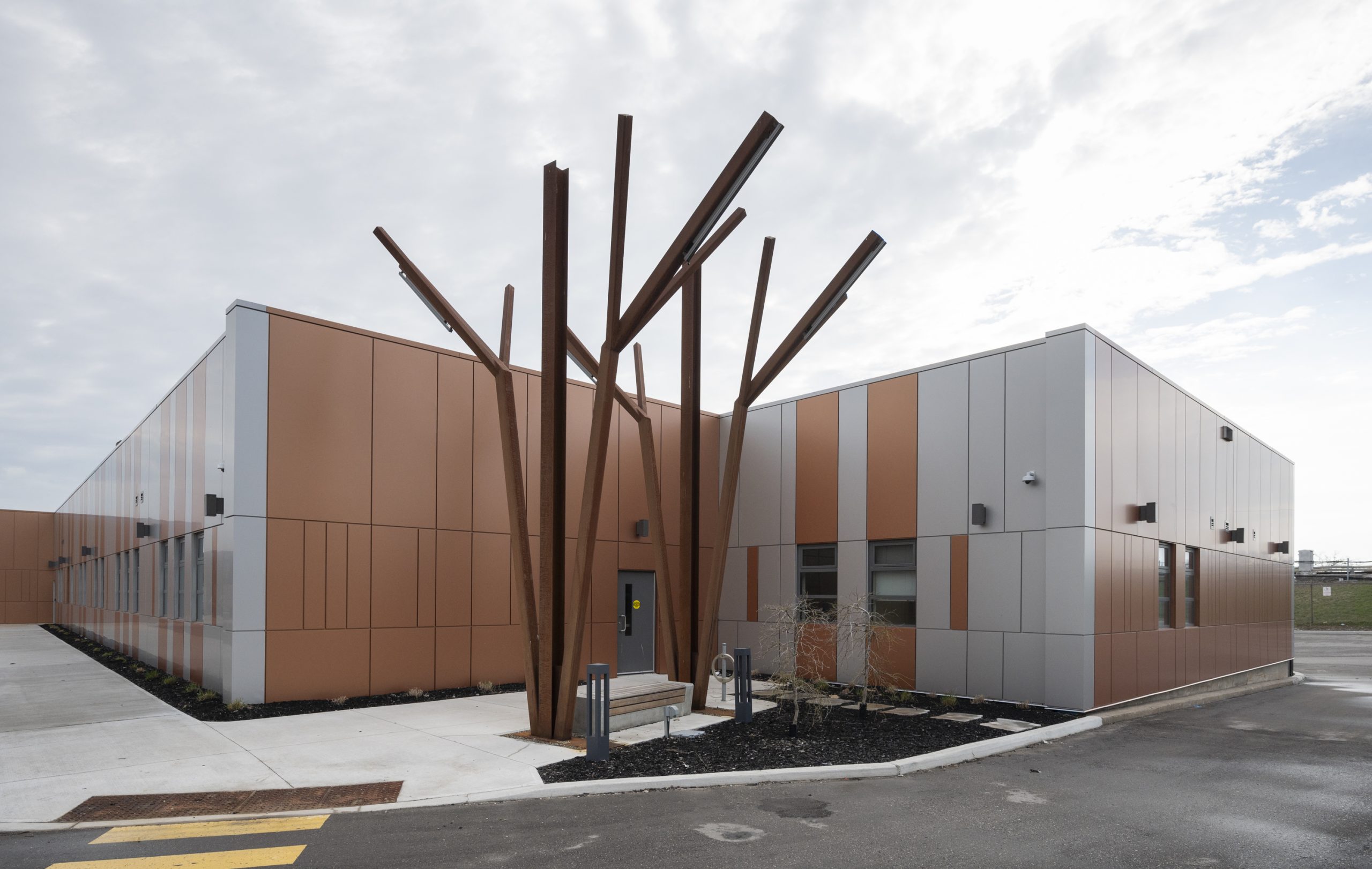 705 Progress Ave. entrance, a low-rise building with a large metal tree-like sculpture in the front