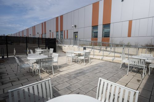 Outdoor patio with interlocking paving stones and white patio furniture