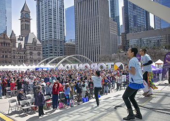 Performers on the stage at Nathan Phillip's Square encouraging a large crowd to participate in an activity
