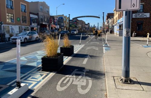 A cycle track is shown with planter boxes and decorative markings on the pavement