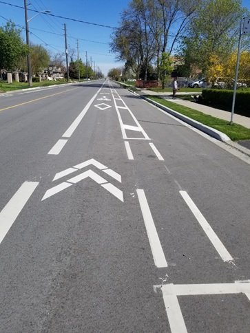 A bike lane is shown on a street between a motor vehicle traffic lane and a parking lane.