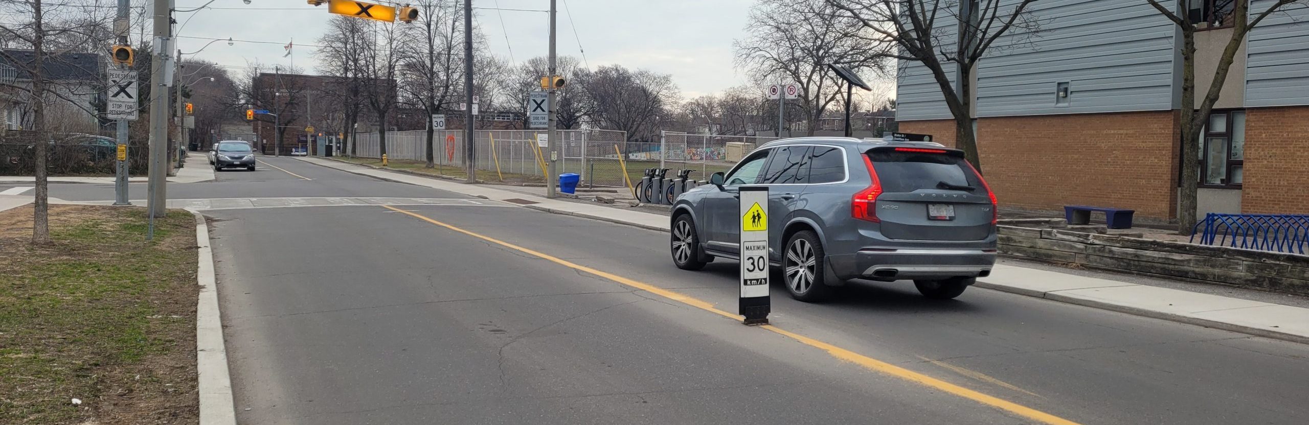 Vehicle passing a flexible in-road sign on Boultbee Ave