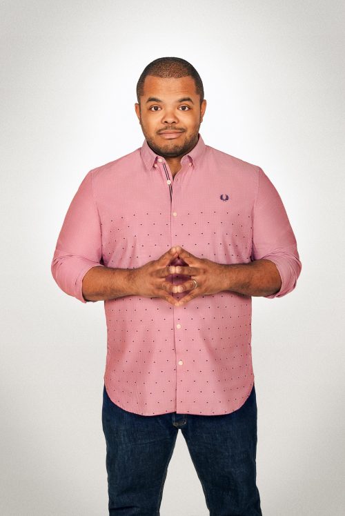 Man faces camera with hands together at his chest