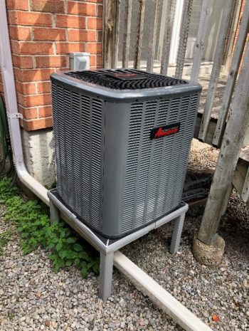 Image of air-source heat pump at exterior of building.