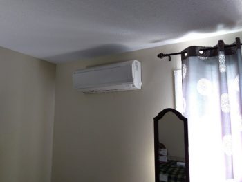 Images of ductless air-source heat pumps in the exterior and interior of a home.