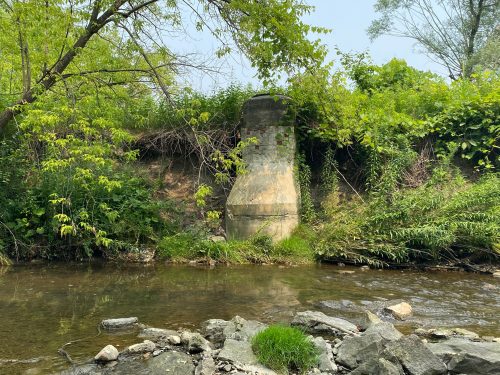 Image of German Mills Creek with exposed sewer manhole. Please contact Tracy Manolakakis for more information at 416 392 2990 or germanmills@toronto.ca