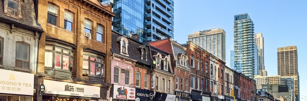 A row of Victorian-era brick buildings with modern storefronts.