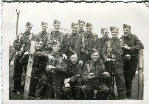 A black and white photo of a group of soldiers posing after training at Exhibition Place.