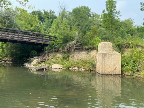 Image of German Mills Creek with exposed sewer manhole. Please contact Tracy Manolakakis for more information at 416 392 2990 or germanmills@toronto.ca