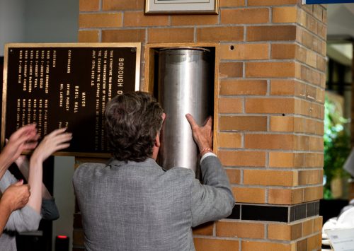 Mayor John Tory removing time capsule from wall