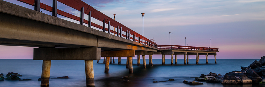 A wooden pier a few feet above the water of the lake.