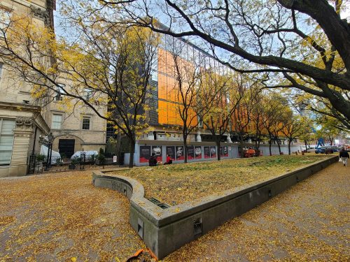 View of St. Lawrence Market, North Building outside showing a park with fallen leaves.