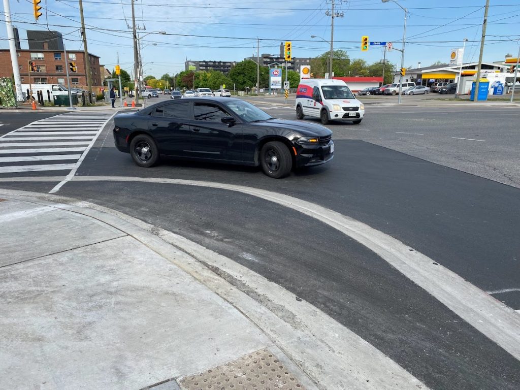 A driver makes a right turn around a truck apron at an intersection. 