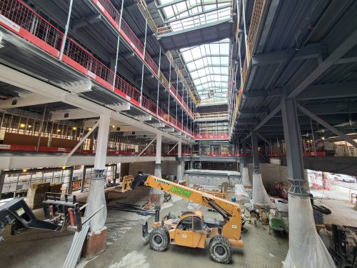 View of St. Lawrence Market, North Building interior showing construction machinery and overhead lights.