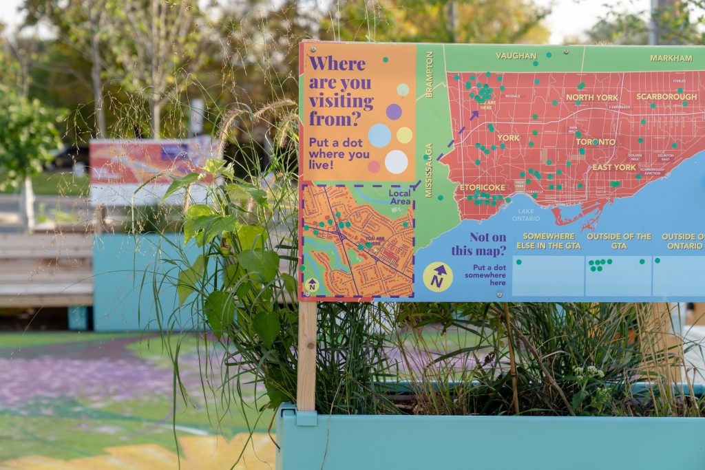 Signage in planter showing a map of Toronto and reads Where are you visiting from? Put a dot where you live